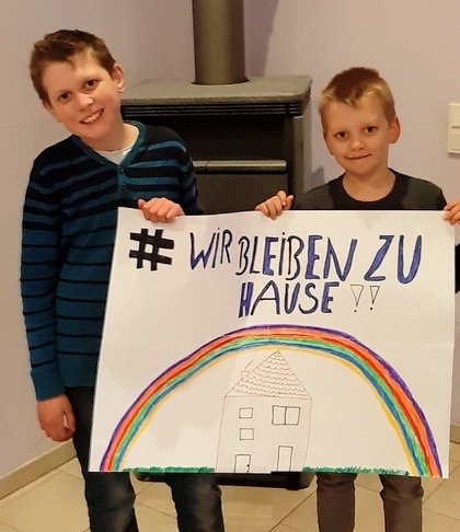 Grafik: Zwei Jungs halten ein groÃŸes Plakat mit Regenbogen in die Kamera.