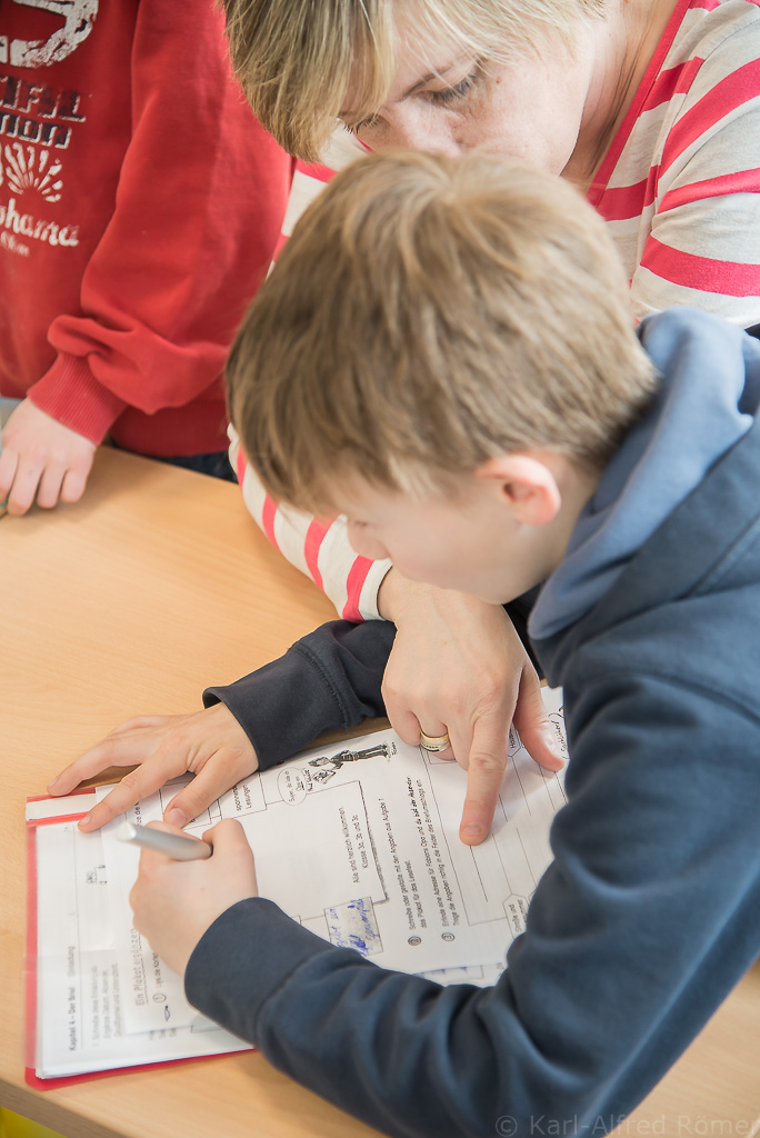 Frau Bonato sitzt mit einem SchÃ¼ler Ã¼ber den Deutsch-Hausaufgaben fÃ¼r z.B. Nachmittagsunterricht