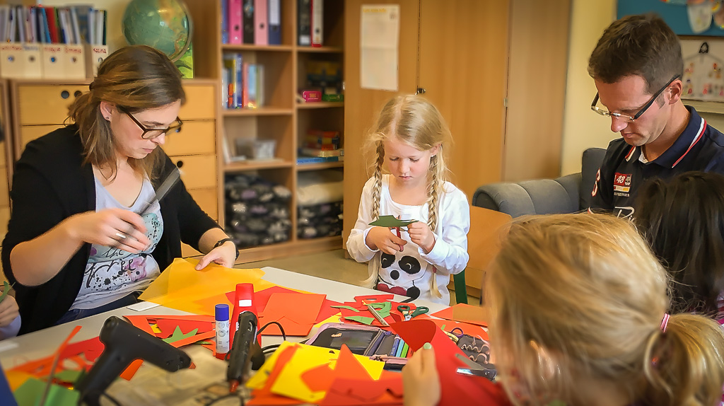 Kinder basteln mit ihren Eltern aus Pappe Laternen